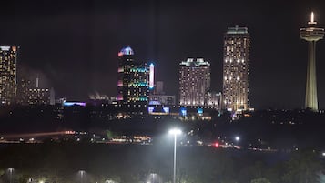 A nighttime cityscape with illuminated skyscrapers and a prominent tower.