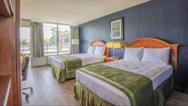 A hotel room with two beds, a desk, and a chair. - Reidsville Inn & Suites (Reidsville)