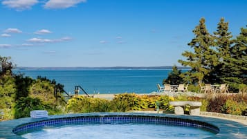 Relax by the ocean-view pool surrounded by lush greenery and comfortable seating.