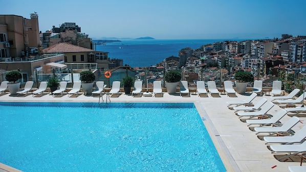 Piscine extérieure en saison, chaises longues