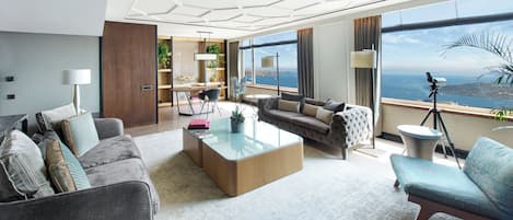 A modern living room with a large window, a sofa, a coffee table, and a dining area.