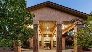 A building with a brick facade, a covered entrance area, and a well-lit interior.