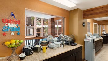 Una cocina con un frutero, una olla de cocción lenta y una cafetera.