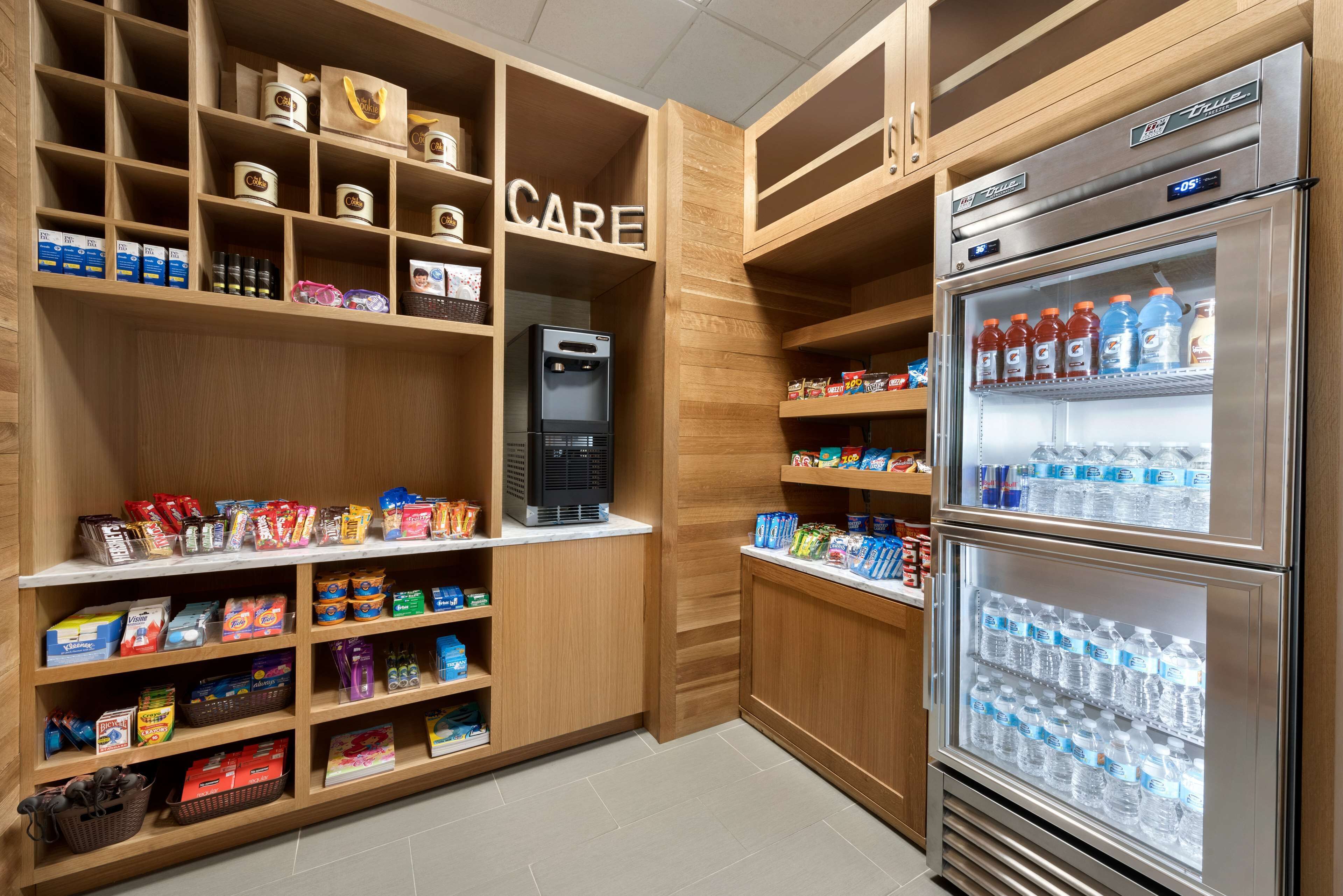 A well-organized store with shelves stocked with snacks, beverages, and toiletries.