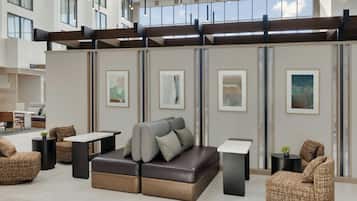 A modern lounge area with a sectional sofa, armchairs, and a coffee table.