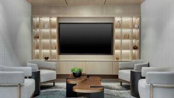A modern home theater room with a large flat-screen TV, comfortable seating, and a decorative wall unit.