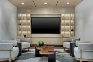 Ein moderner Hauskino-Raum mit einem großen Flachbildfernseher, bequemen Sitzgelegenheiten und einer dekorativen Wandanlage.