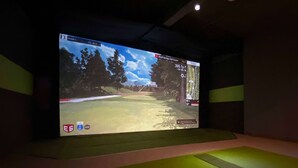 A large screen displaying a golf course simulation game. - Ramada by Wyndham Lethbridge (Lethbridge)