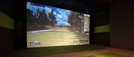Un gran pantalla que mostra un simulador de joc de golf.