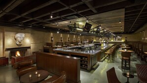 Un restaurant doté d’un bar central, de différents espaces pour s’asseoir et d’une cheminée.