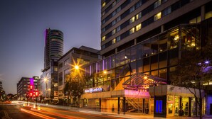 A hotel with a modern glass facade, a prominent entrance, and a visible sign. - Hilton Leeds City Hotel (Leeds)