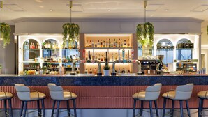 A bar area with a counter, stools, and shelves of bottles. - Hilton Leeds City Hotel (Leeds)