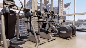 A gym with treadmills, ellipticals, and a rowing machine. - Hilton Leeds City Hotel (Leeds)
