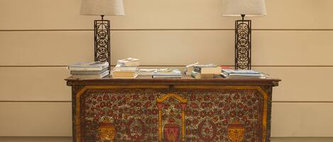 A wooden cabinet with intricate floral designs and two lamps on either side.