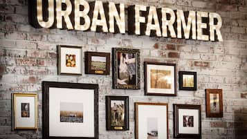 A wall with the words 'URBAN FARMER' and various framed photographs.