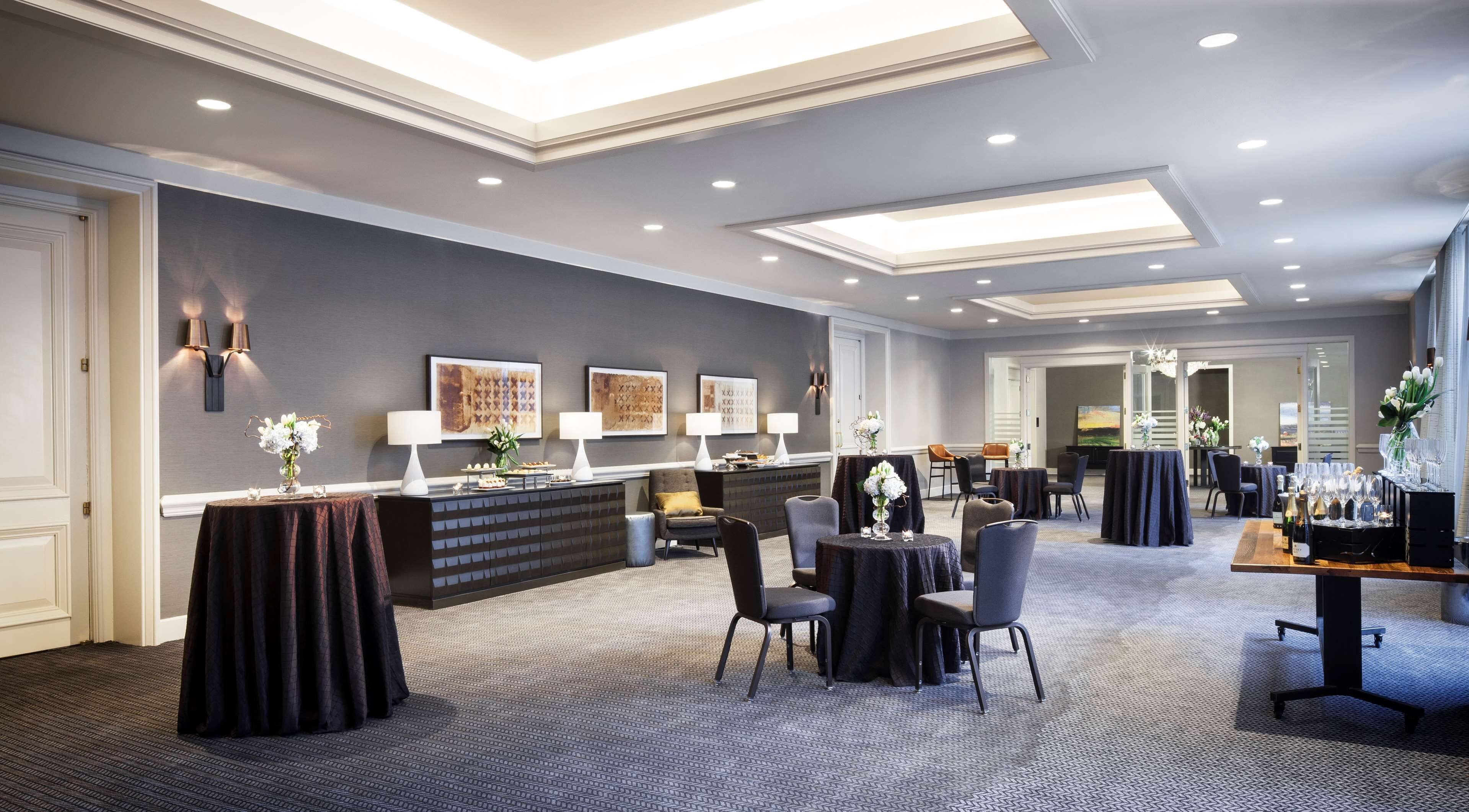 Um lobby moderno de hotel com balcão de recepção, área de estar e espaço para refeições.