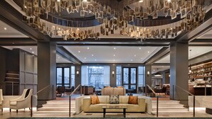 A spacious lobby with a central seating area, a staircase, and a bar. - The Logan Philadelphia, Curio Collection by Hilton (Philadelphia)