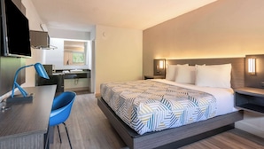 A hotel room with a bed, a desk, a chair, and a television. - Motel 6 Charlotte, NC - Coliseum (Charlotte)