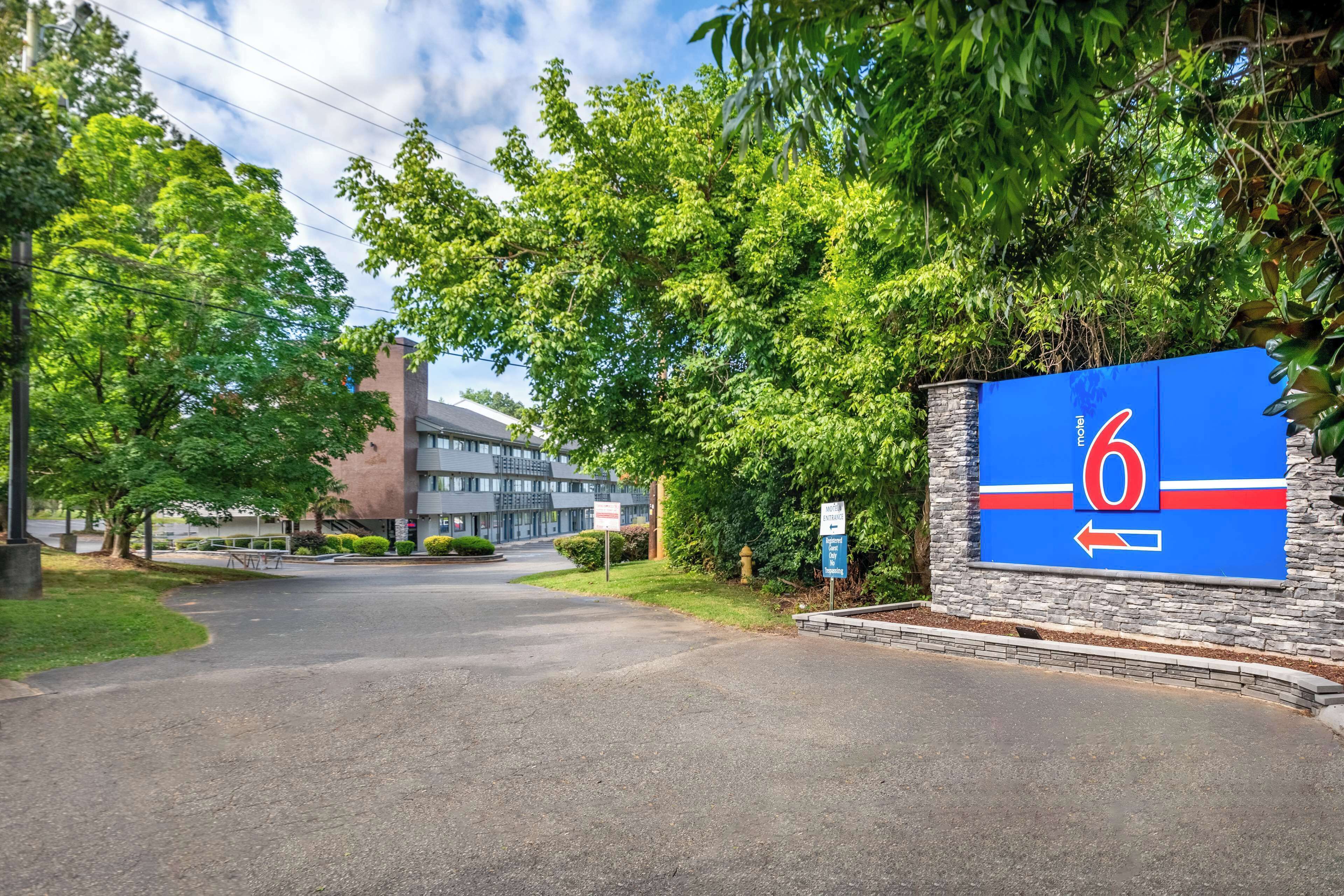 A hotel entrance with a large blue sign featuring a red arrow and the number 6.