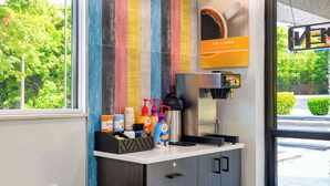 A coffee station with a coffee machine, a coffee grinder, and various coffee products. - Motel 6 Charlotte, NC - Coliseum (Charlotte)