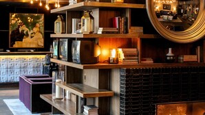 A modern interior with wooden shelves, a fireplace, and a round mirror. - Thompson Chicago, by Hyatt (Chicago)