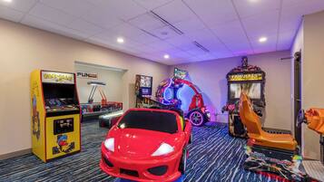 Experience the ultimate gaming getaway in this retro arcade-themed room, featuring a life-size sports car model, classic arcade machines, and a racing simulator.