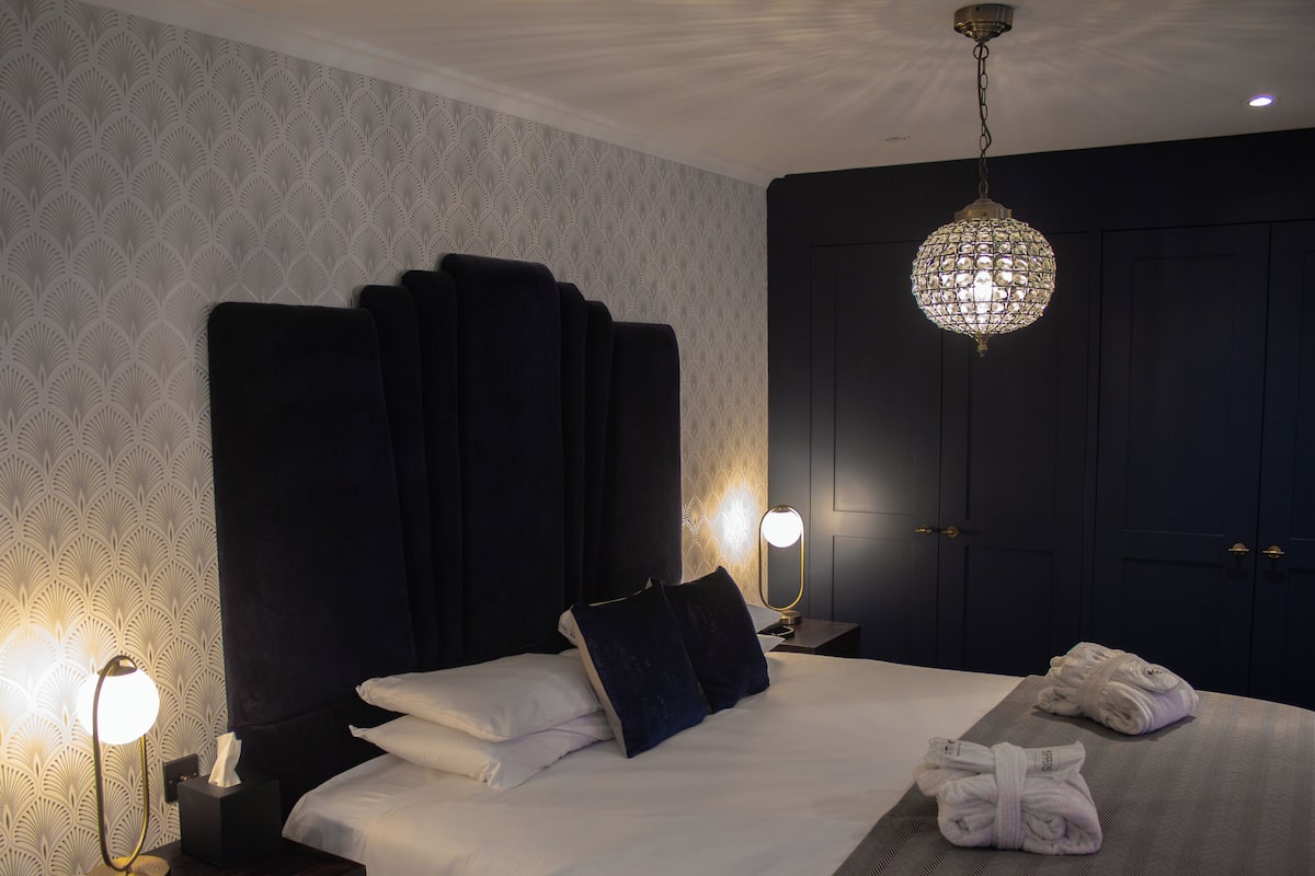 Ein Hotelzimmer mit einem großen Bett, Nachttischlampen, einem Kleiderschrank und einer Deckenleuchte.