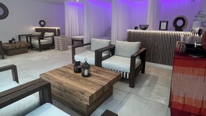 Un área de descanso moderna con sofás, una mesa de centro de madera y una recepción.