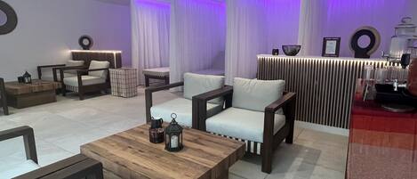 A modern lounge area with sofas, a wooden coffee table, and a reception desk.