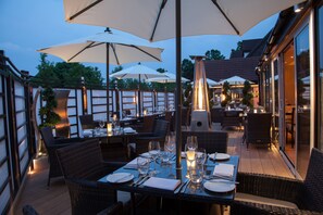 An outdoor dining area with tables, chairs, and umbrellas. - The Winchester Hotel & Spa (Winchester)