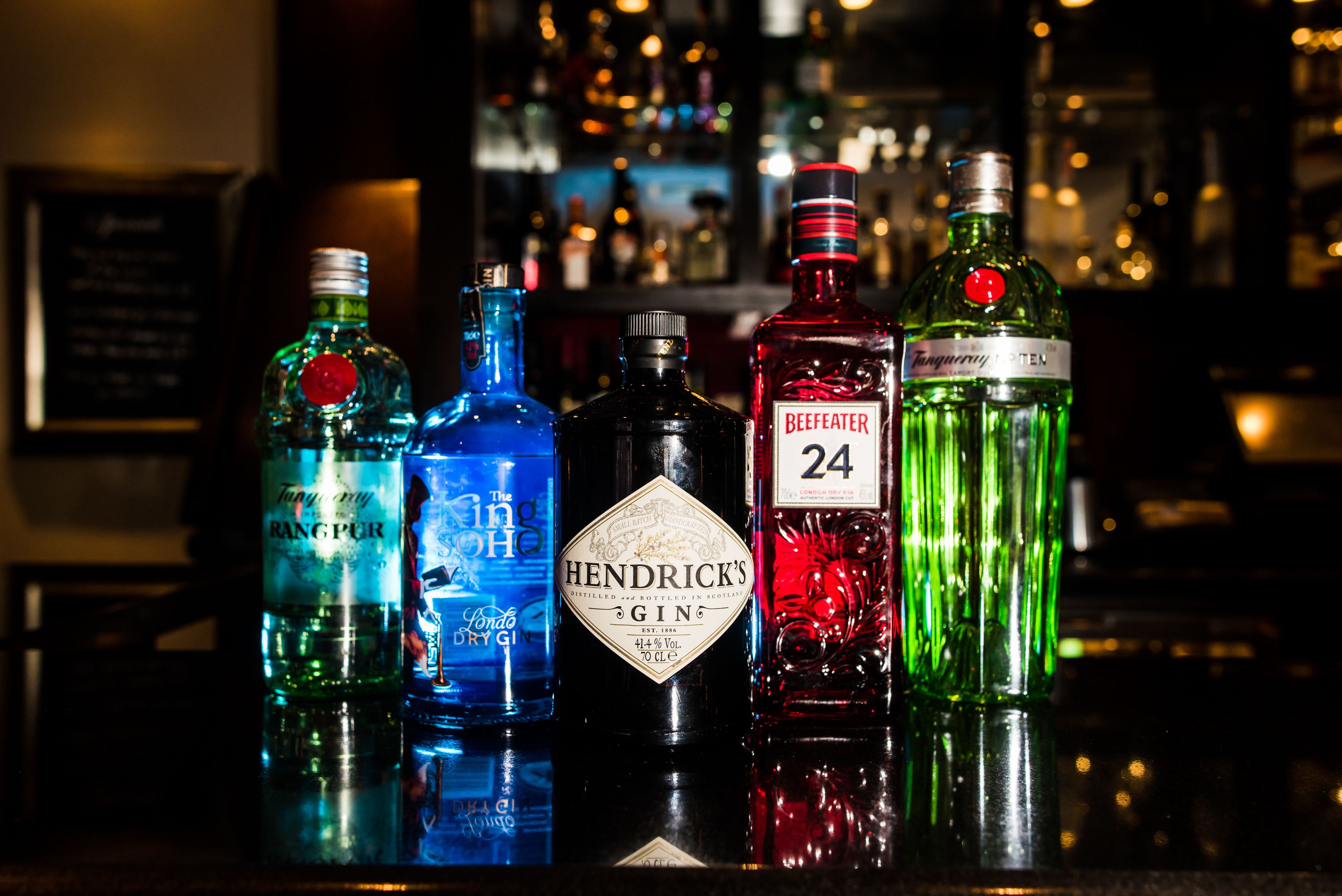 Verschiedene Spirituosenflaschen auf einer Bar.