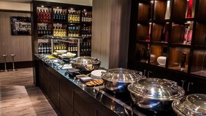 Zona de bufé con diferentes opciones de comida y una variedad de bebidas.
