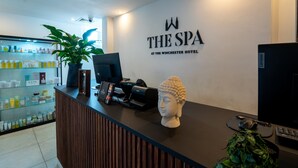 Una recepción con el logotipo de 'The Spa at the Winchester Hotel', una impresora, un ordenador y una estatua de Buda.
