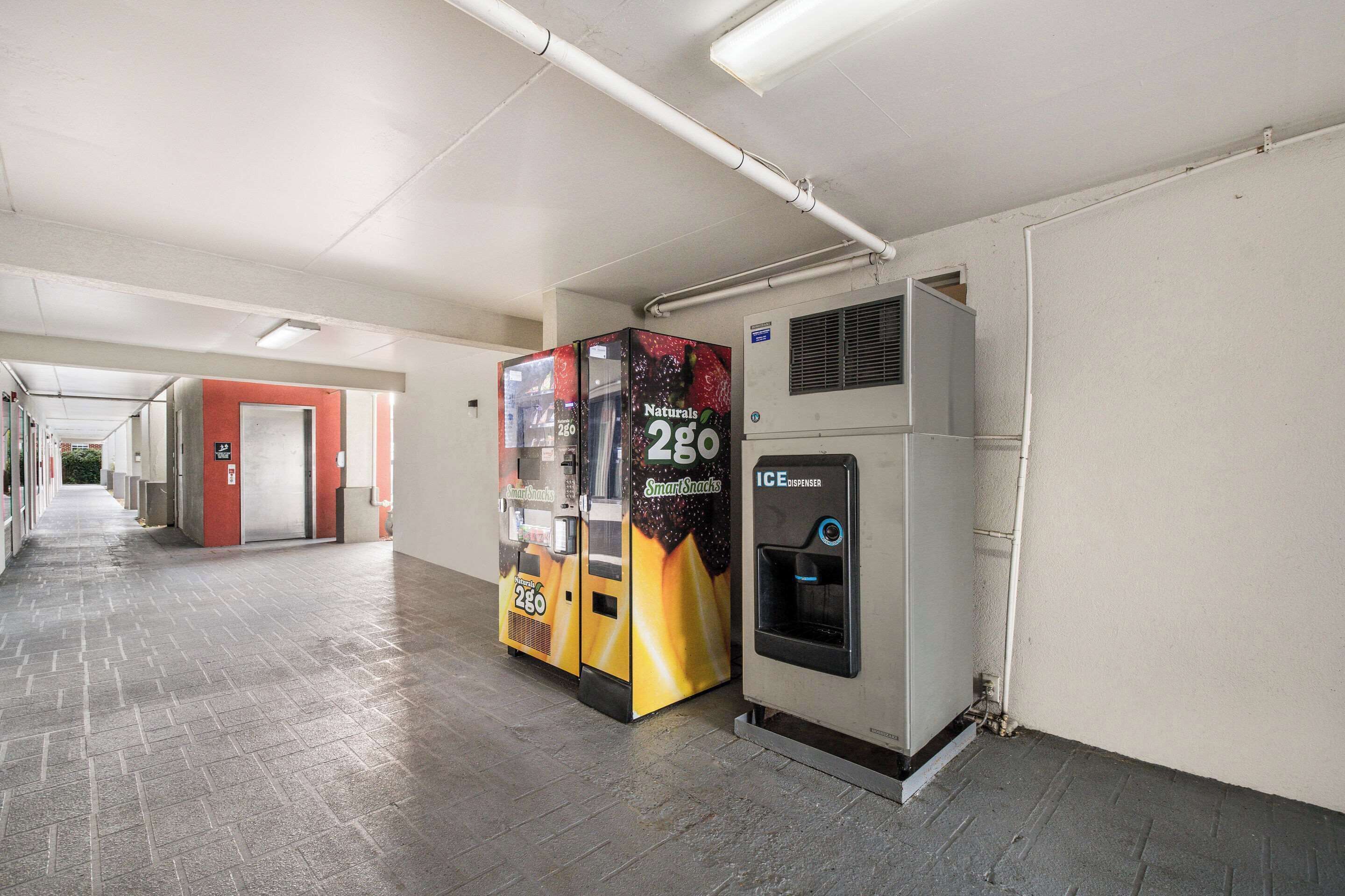 A corridor with vending machines and an ice dispenser.