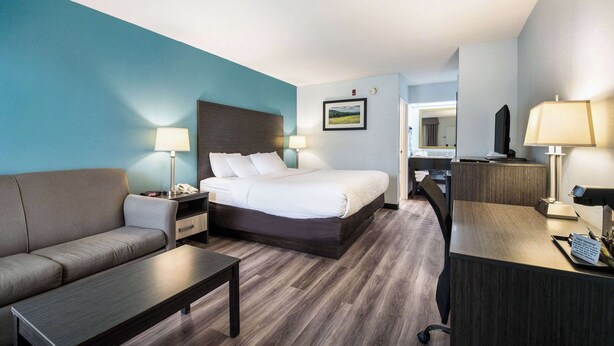 Ein Hotelzimmer mit Bett, Sofa, Schreibtisch und Stuhl.