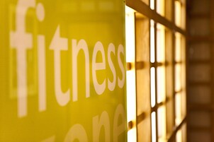 Ein gelbes Schild, auf dem das Wort 'Fitness' teilweise zu sehen ist.