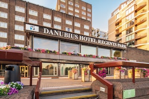 The exterior of Danubius Hotel Regents Park with a brick facade, large windows, and flower boxes along the entrance.