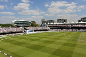 A stadium with a modern architectural design, featuring a large seating area and a well-maintained grass field.