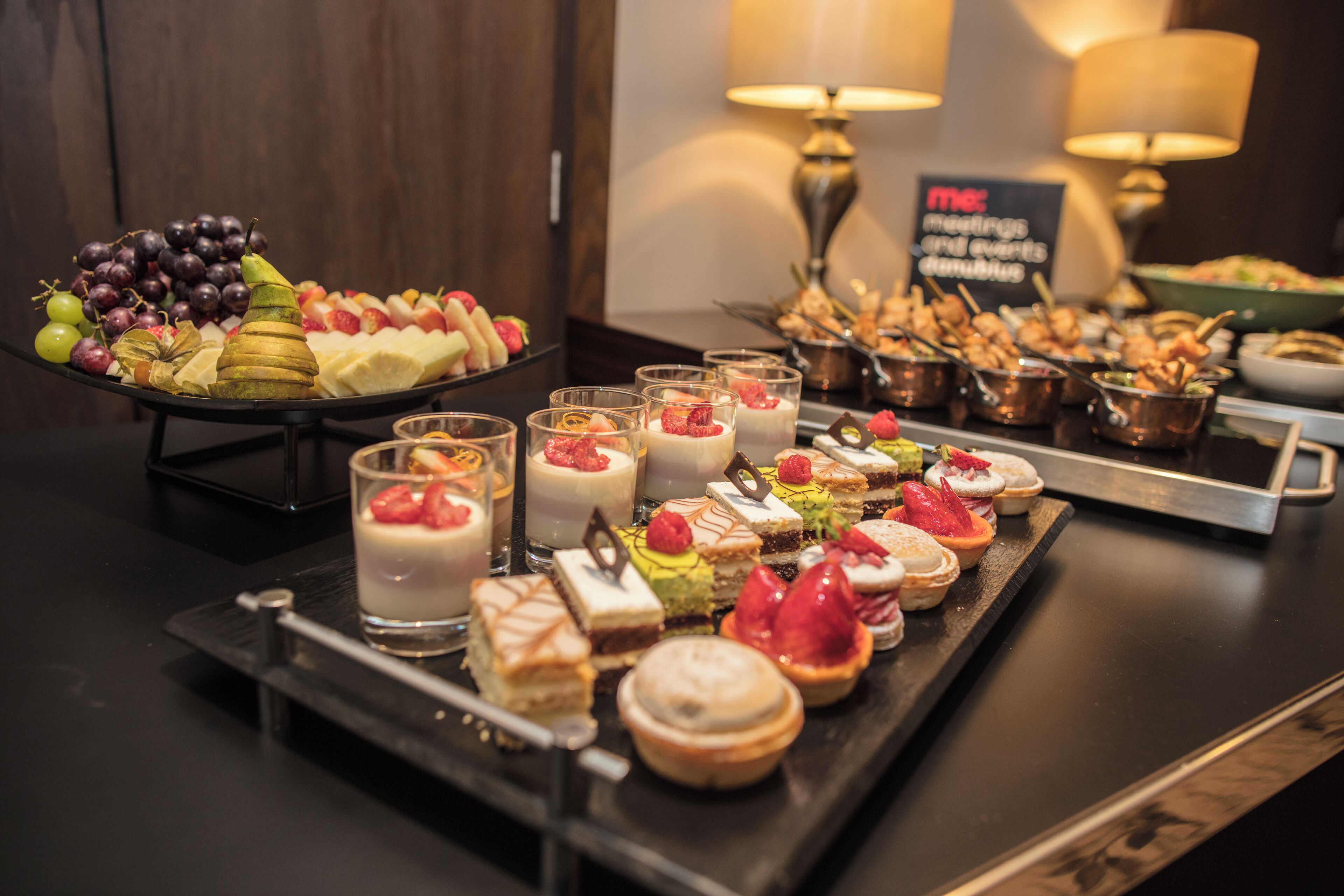 A buffet with various desserts and fruits.
