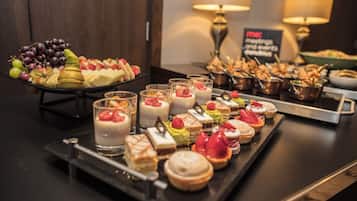 A buffet with various desserts and fruits.