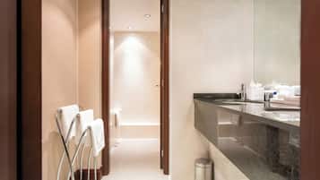 Un baño moderno con un espejo grande, un lavabo y un perchero para toallas.
