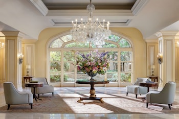 A luxurious lobby with a grand chandelier, a piano, and a modern sectional sofa. at Langham Huntington, Pasadena, Los Angeles