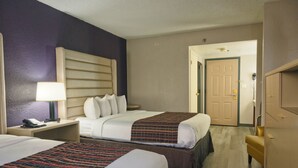 A hotel room with two beds, a nightstand with a lamp, a telephone, and a wardrobe. - The Palms Inn & Suites (Miami)