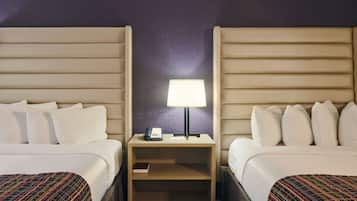 Ein Hotelzimmer mit zwei Betten, einem Nachttisch mit Lampe, Telefon und Buch.