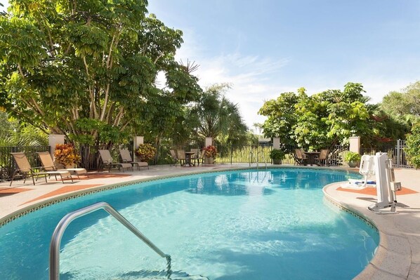 Una piscina al aire libre, tumbonas