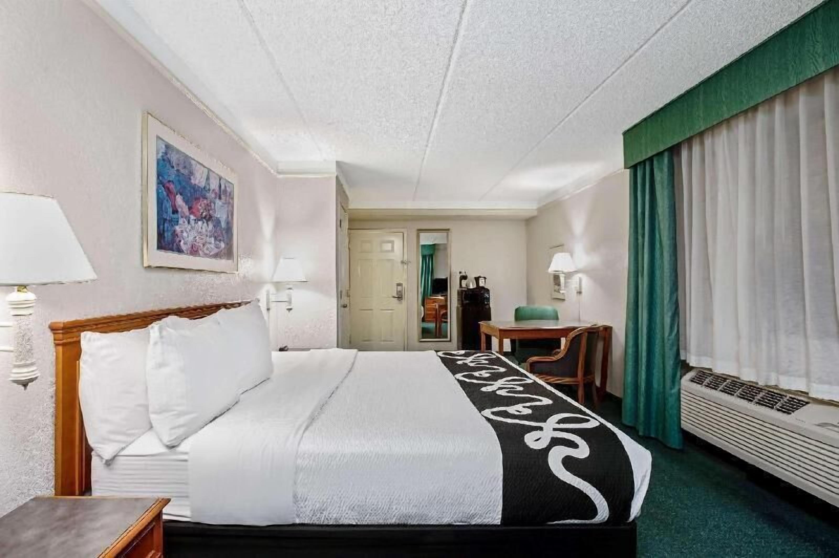 Premium bedding, desk, laptop workspace, blackout drapes