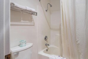 A bathroom with a toilet, a sink, a shower, and a towel rack. - Motel 6 Safford, AZ (Safford)