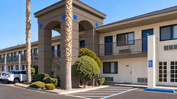 A multi-story hotel with a parking lot, including a handicapped parking space.