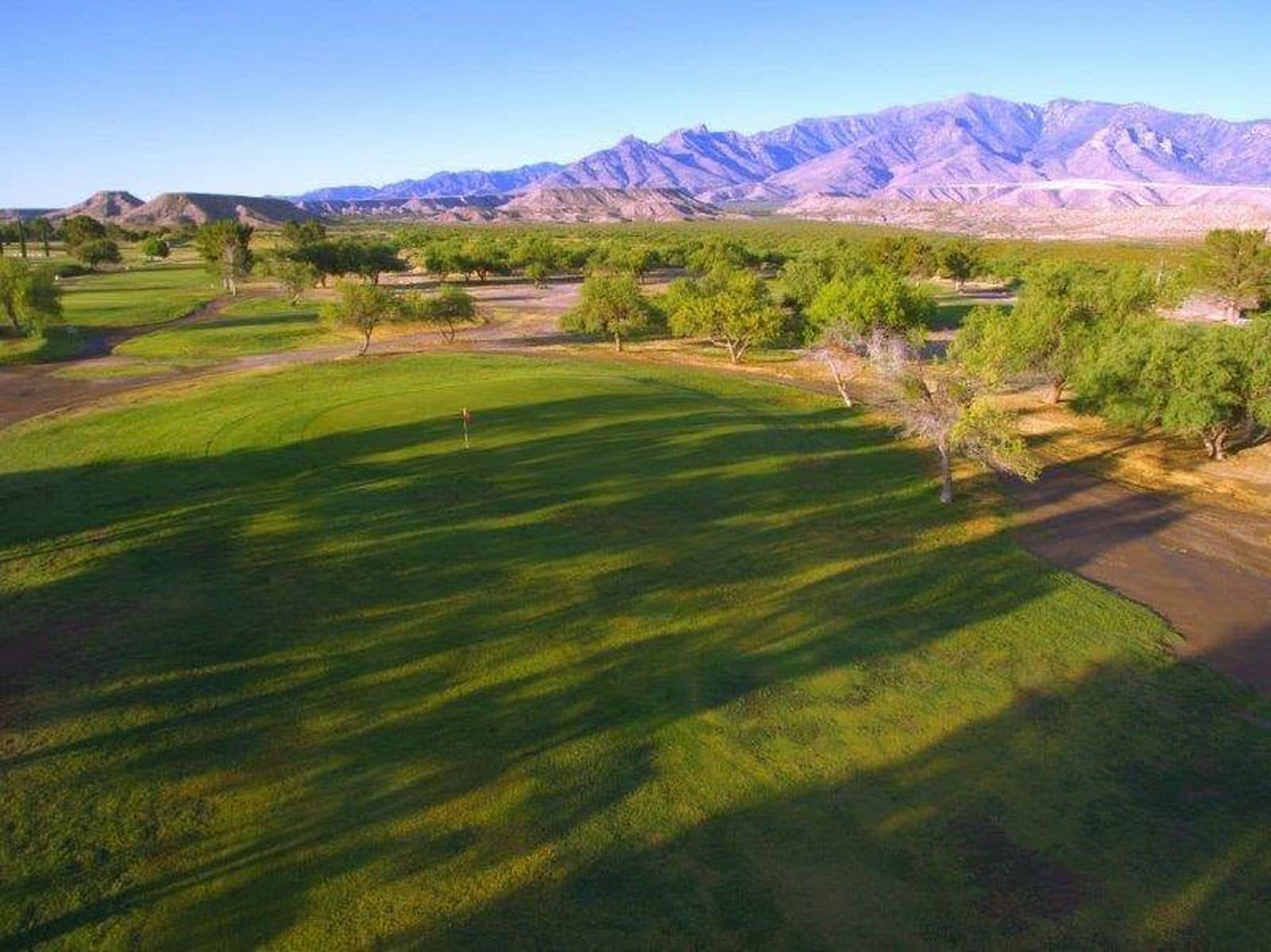 A golf course with a mountainous backdrop.