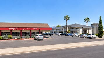 A commercial building with a red facade and a sign for 'Jerry's Restaurant' with a parking lot in front.